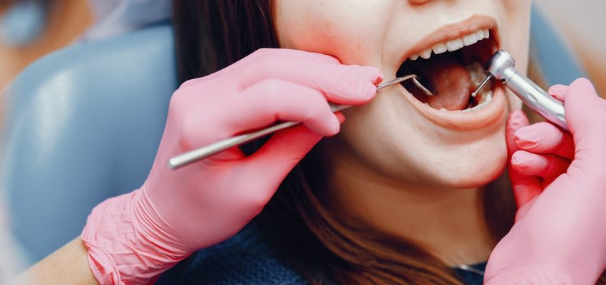 Girl talking to the dendist. Beautiful lady in the dentist's office. Woman in a uniform